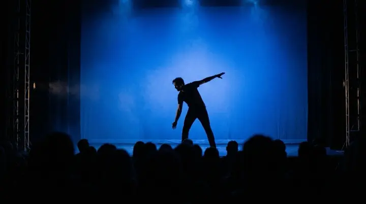 Solo dancer under a single spotlight on an empty stage