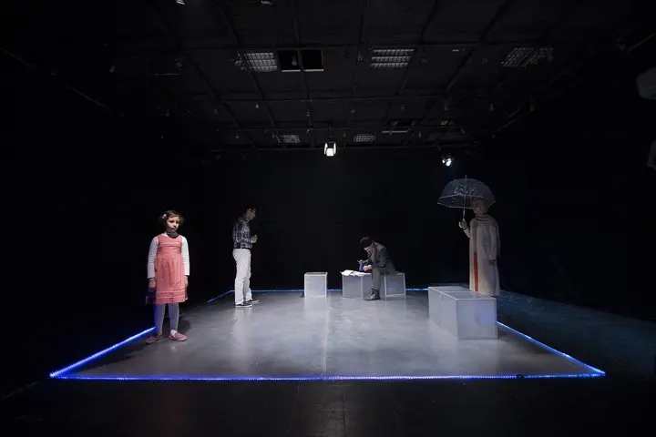 An experimental theatre set lit for a scene